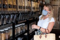 Frau mit Gesichtsmaske kauft in abfallfreiem Laden ein — Stockfoto