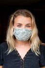 Portrait of young blond woman wearing blue face mask. — Stock Photo