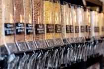 Close up of food dispensers with dried pasta in a waste free wholefood store. — Stock Photo