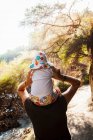 Mutter gibt ihrem kleinen Mädchen eine Huckepackfahrt auf Naturpfad am Thermalbad — Stockfoto
