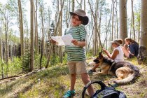 Menino de 7 anos segurando mapa do tesouro na floresta de árvores de Aspen — Fotografia de Stock