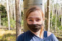 Adolescente con máscara COVID-19 en bosque de árboles de Aspen - foto de stock
