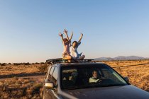 Teenagermädchen und ihr jüngerer Bruder im SUV auf Wüstenstraße unterwegs — Stockfoto