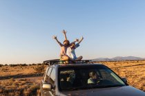 Ragazza adolescente e suo fratello minore in cima alla macchina SUV guida su strada deserta — Foto stock