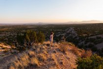 Niño con vistas al increíble paisaje de la cuenca del Galisteo, Santa Fe, NM - foto de stock