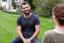 Man and female therapist seated in a garden, as a therapy session — Stock Photo