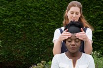 Terapeuta com as mãos em templos de clientes, sessão de terapia ao ar livre — Fotografia de Stock