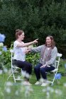 Woman and female therapist sitting at an alternative therapy session in a garden. — Stock Photo