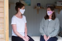 Mujer y terapeuta usando máscaras, en una sesión de terapia - foto de stock