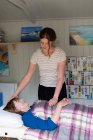 Frau auf der Couch: Therapeutin legt Hände auf Kopf und Bauch — Stockfoto