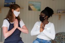 Alternative Therapiesitzung, Therapeutin und Klientin, Frauen in Gesichtsmasken mit den Händen zusammen. — Stockfoto