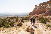 Family hiking on a trail through a protected canyon landscape — Stock Photo