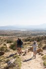 Three people, family hiking on a trail through a protected canyon landscape — Stock Photo