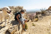 Young boy hiking with his dog on Chimney Rock trail, through a protected canyon landscape — Stock Photo