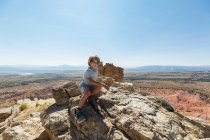 Niño caminando a la cima de la roca de la chimenea hito en un paisaje de cañón protegido - foto de stock