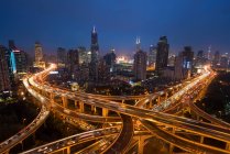 Підвищений автомобільний перехід і горизонт Шанхаю, Китай у сутінках. — стокове фото