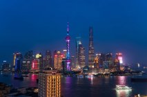 Skyline del distrito financiero de Pudong a través del río Huangpu al atardecer, Shanghái, China. - foto de stock