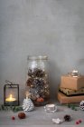 Christmas decorations, close up of Christmas decorations, presents, tea lights and pine cones. — Stock Photo