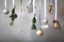 Decorazioni natalizie, palline d'argento, bianco e oro su nastri su fondo grigio. — Foto stock