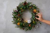 Christmas decorations, close up of person decorating Christmas wreath with ornaments. — Stock Photo