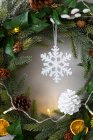 Рождественские украшения, закрытие белой шишки и снежинки на рождественском венке. — стоковое фото