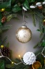 Decoraciones de Navidad, primer plano de la bola de oro y cono de pino blanco en la corona de Navidad. - foto de stock