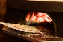 Primer plano de pizza en un horno a leña en un restaurante. - foto de stock