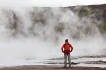 Mujer parada junto a piscinas geotermales, suroeste de Islandia - foto de stock
