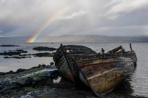 Rainbow and beached old wooden fishing boats on shore at Salen — Stock Photo