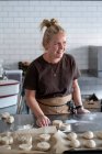 Mulher trabalhando em uma cozinha, preparando massa de doces dinamarqueses. — Fotografia de Stock