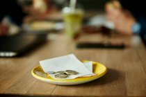 Moedas e conta na mesa do restaurante, close-up — Fotografia de Stock