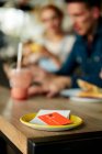 Persone a un tavolo da caffè, un piattino con ricevuta e carta di credito. — Foto stock