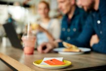 People at a cafe table, a saucer with till receipt and credit card. — Stock Photo