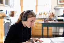 Teenager-Mädchen trägt Kopfhörer, Zeichnung auf Papier — Stockfoto