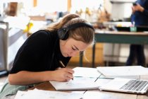 Teenager-Mädchen trägt Kopfhörer, Zeichnung auf Papier — Stockfoto
