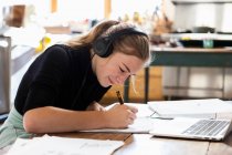 Adolescente usando fones de ouvido, desenho em papel — Fotografia de Stock