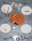 Remains of a pizza meal with leftover slice and crusts, glasses and plates and napkins. — Stock Photo
