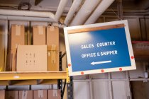 Sales counter sign and cardboard boxes on shelf in warehouse. — Stock Photo