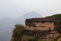 Cabaña de montaña dilapidada y vista a la montaña - foto de stock