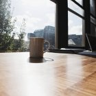Mug on desk in urban office — Stock Photo