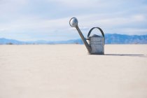 Watering can on salt flat. — Stock Photo