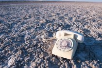 Vintage telephone on salt flat or sand. — Stock Photo