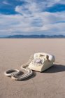 Vintage telephone on salt flat. — Stock Photo