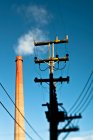 Power line with industrial chimney — Stock Photo