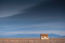 Cottage em uma paisagem rural com montanha atrás. — Fotografia de Stock