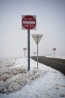 Sinais rodoviários na estrada em paisagem invernal. — Fotografia de Stock