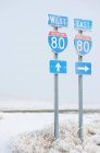 Highway signs on road in wintry snowy landscape. — Stock Photo