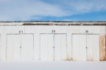 Portas numeradas no edifício de armazenamento de metal ondulado. — Fotografia de Stock