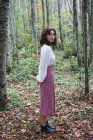 Retrato de una niña de diecisiete años parada en un frondoso bosque en otoño, Discovery Park, Seattle, Washington - foto de stock