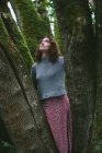 Портрет сімнадцятирічної дівчини, що стоїть перед мохоподібним кленовим деревом — стокове фото